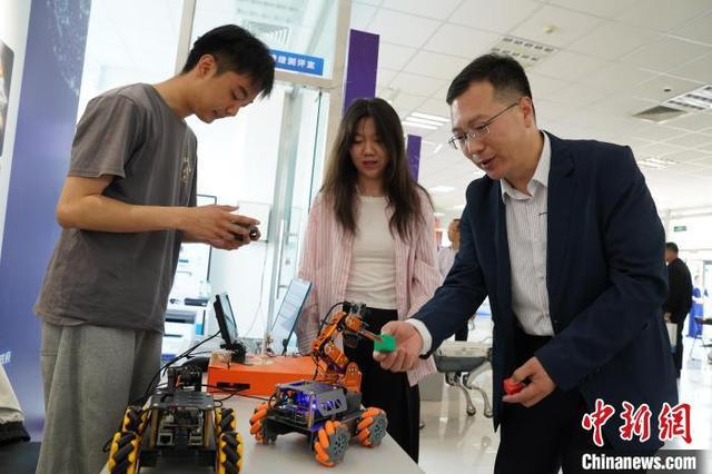 图为展会上大学生研制的智能分拣小车吸引参观者观看体验。王继军 摄