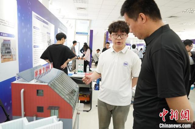 图为展会上的人工智能产品吸引参观者驻足观看咨询。王继军 摄