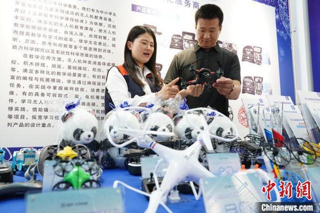 图为展会上参展商向参观者展示无人机产品。王继军 摄