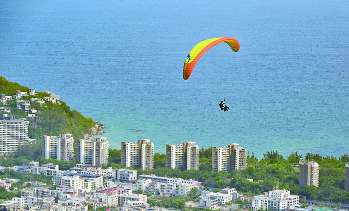 搭客在海南陵水红角岭外洋滑翔伞遨游营地体验滑翔伞遨游。 新华社图