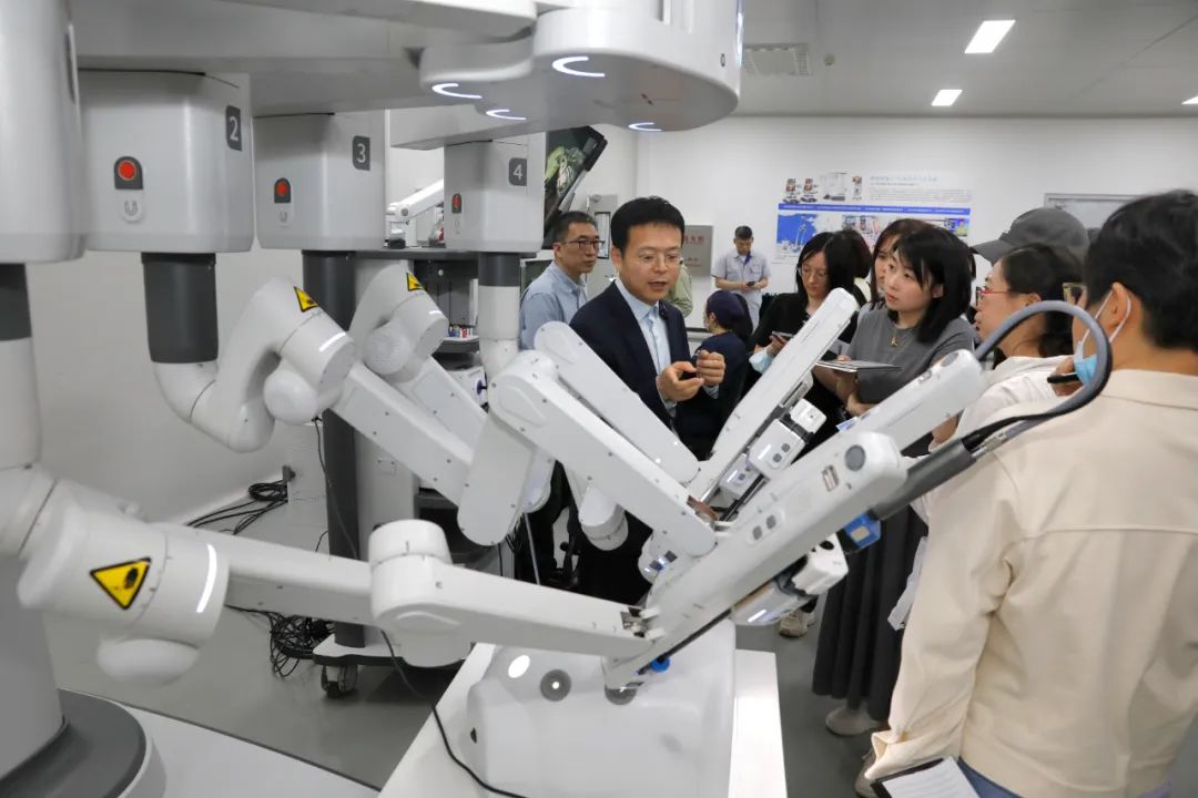 闫志远（左二）向记者讲解康多手术机器人。王欣摄