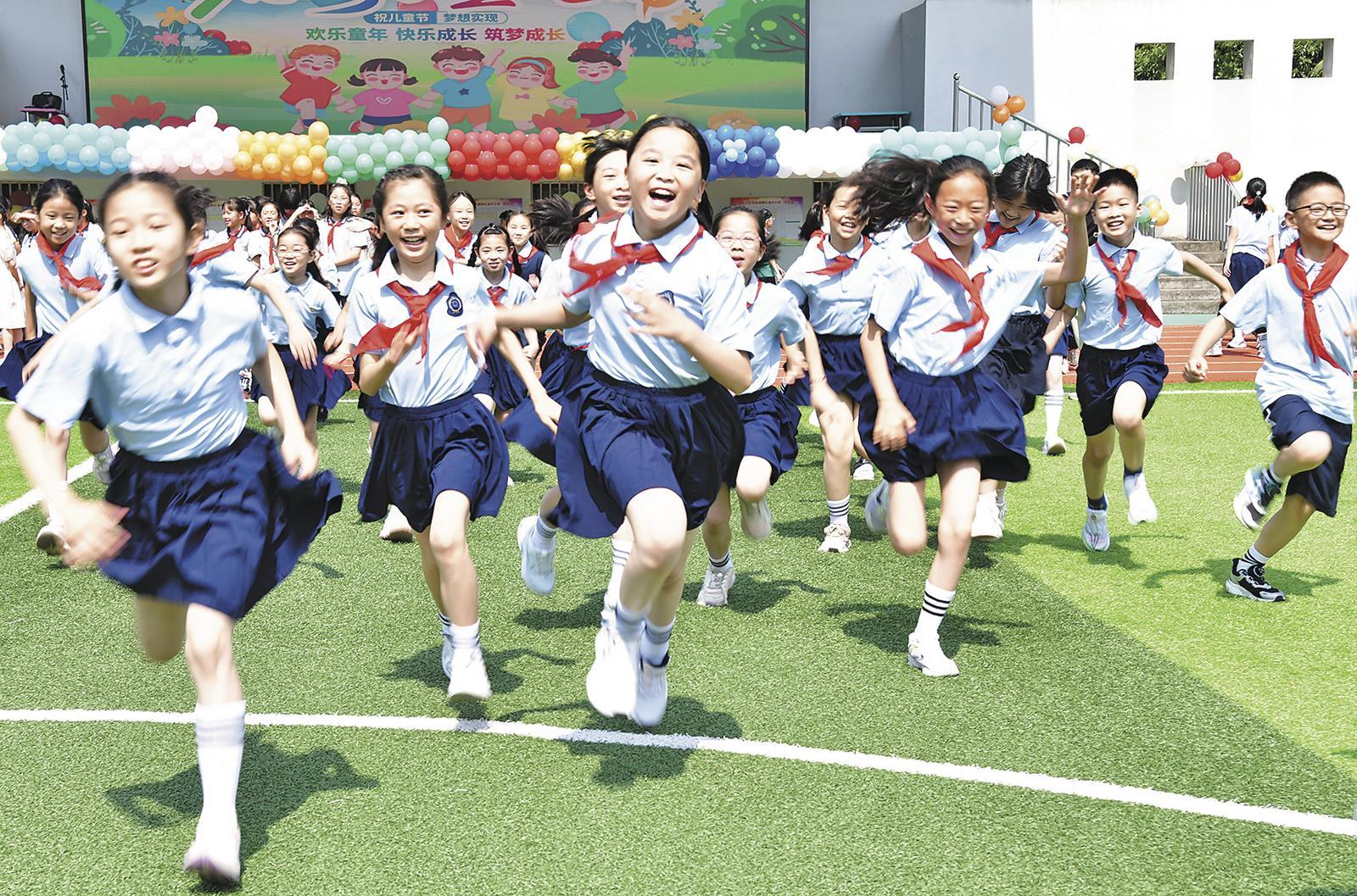5月30日,浙江省建德市明珠小学的小学生在操场上欢庆奔跑