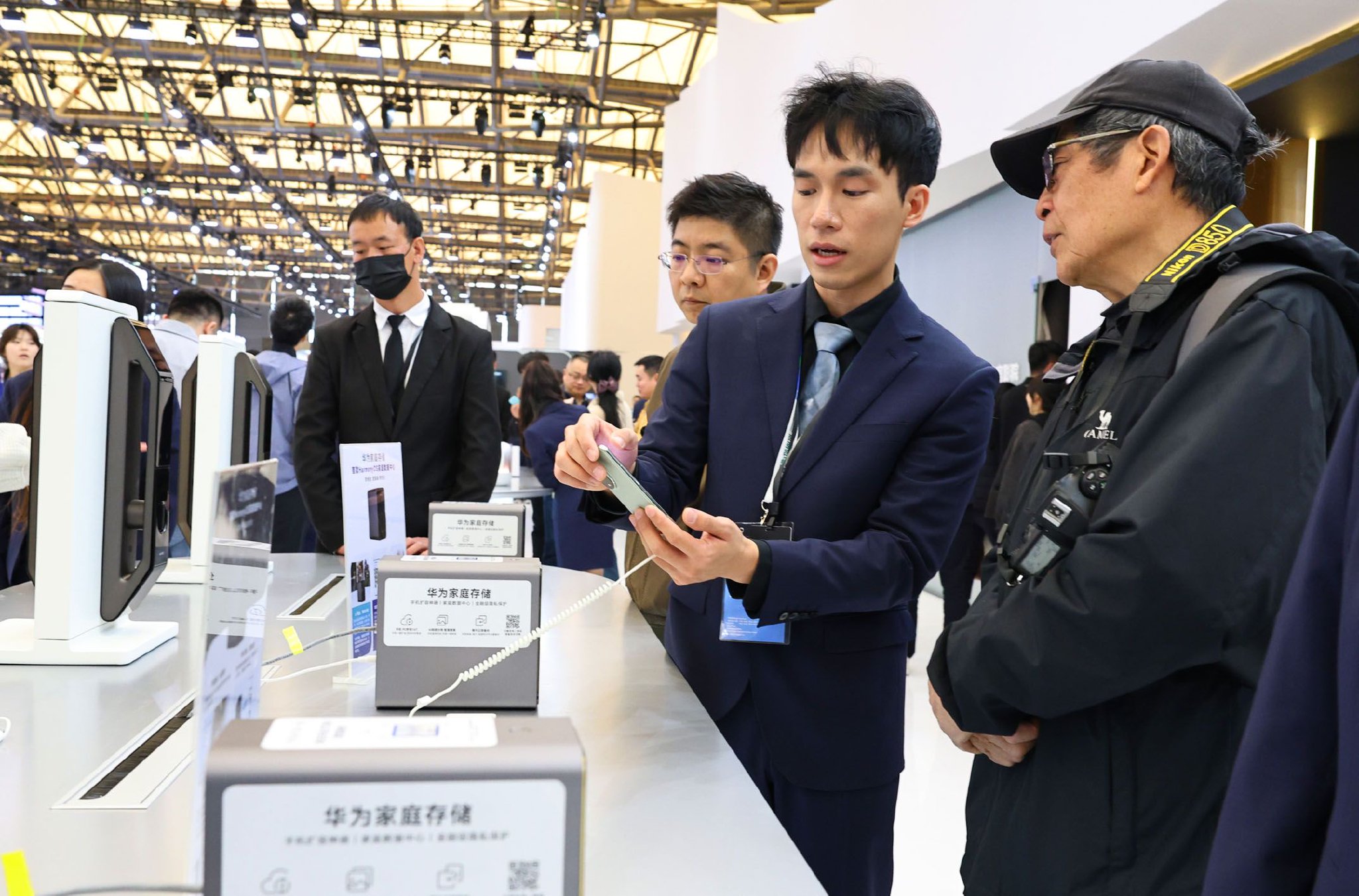 图为在2025中国家电及消费电子博览会上工作人员向参观者介绍一个家庭数据中心存储设备。　新华社记者　方喆　摄