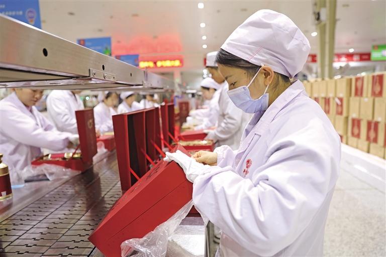 西凤酒现代化成品包装车间里,工人在打包产品(资料照片)。 受访单位供图