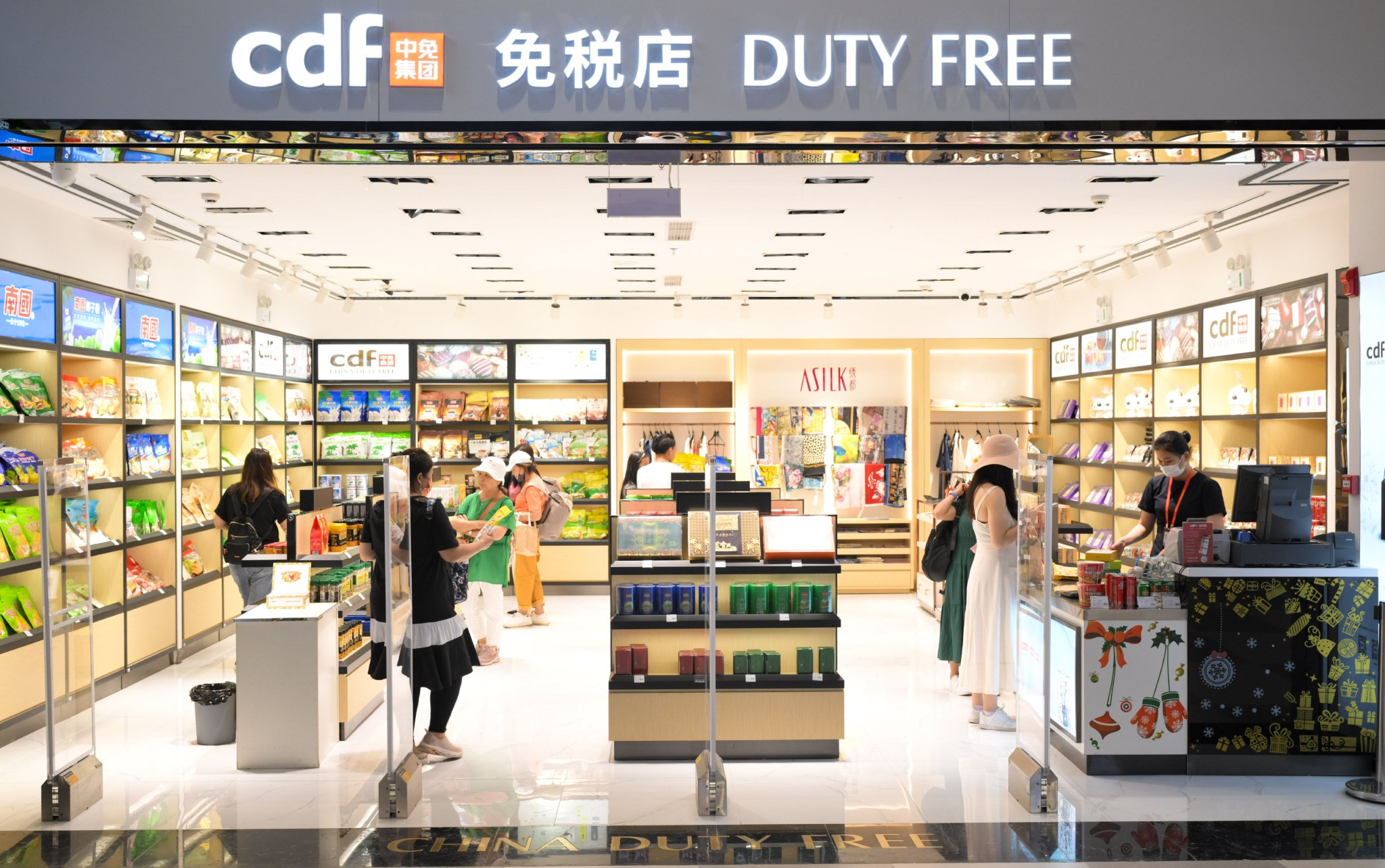 旅客在三亚凤凰国际机场国际航站楼内的免税店选购商品。　　新华社记者　杨冠宇　摄