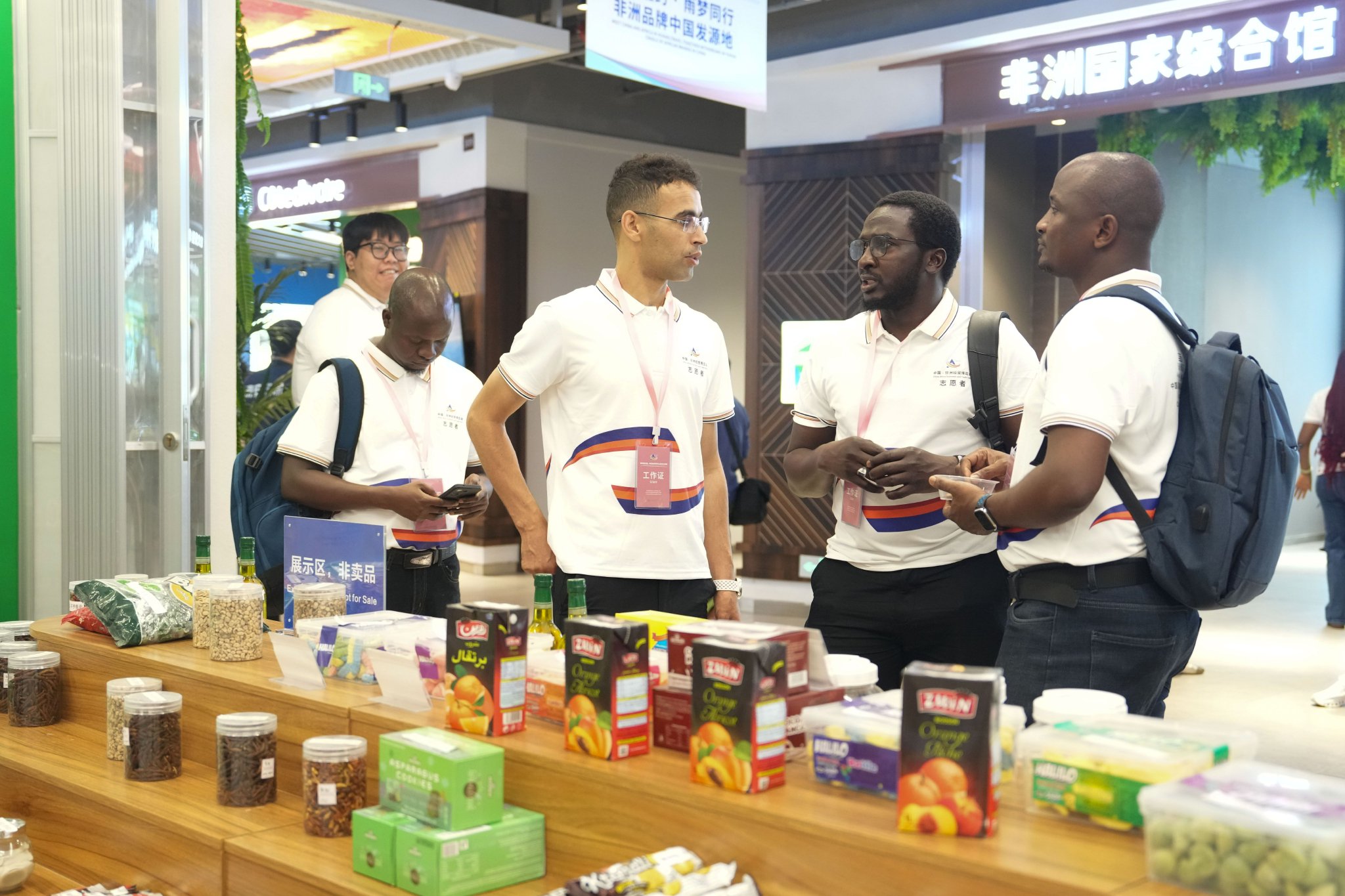 6月12日，志愿者在第四届中国－非洲经贸博览会高桥分展馆查看商品展示情况。