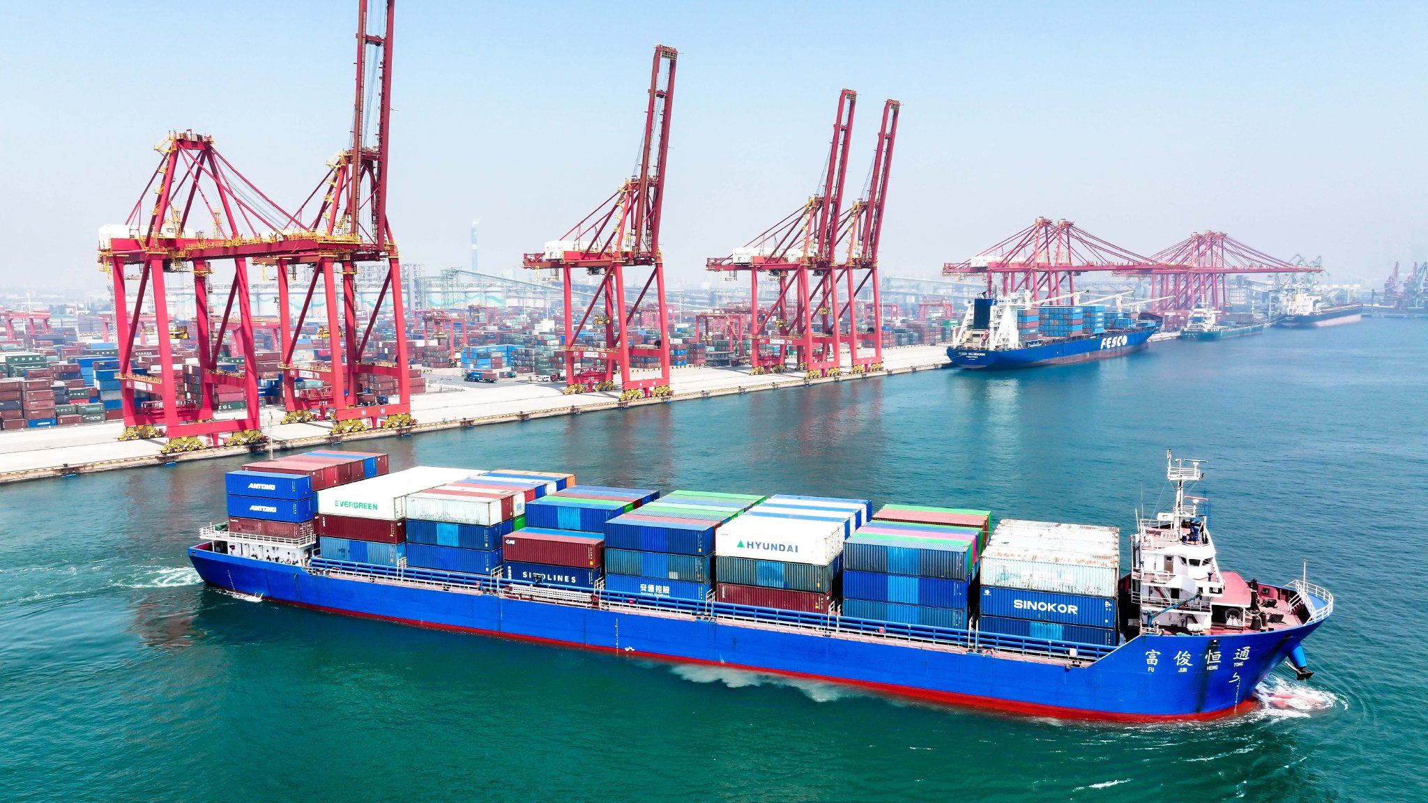 5月20日,在山东港口日照港集装箱码头,满载集装箱的船舶驶离港口