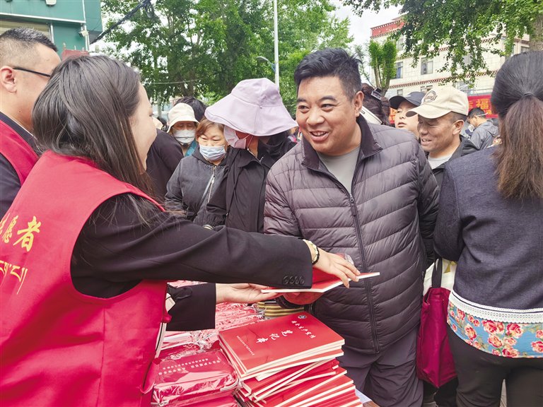 工作人员给社区居民发放安全宣传资料。记者 张雪芳 摄