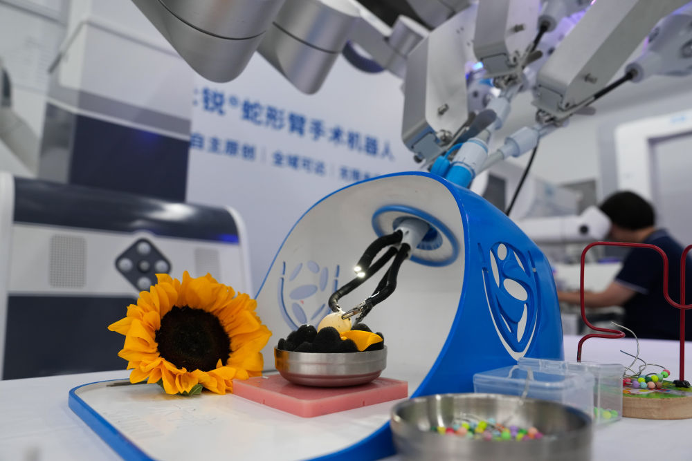 6月18日,工作人员在使用术锐蛇形臂手术机器人进行剥生鹌鹑蛋壳展示。新华社记者郑焕松 摄