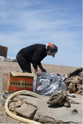 ▲孟根正拆开从拼多多上网购回来的发电机。陈蕾|摄