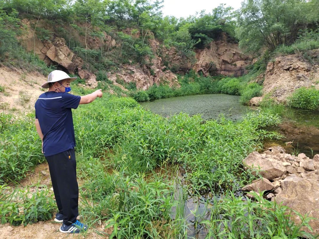 山东乳山非法倾倒固废事件调查:企业倾倒固废称是“暂存”(图1) 村民向《中国新闻周刊》指认康达公司倾倒现场。 摄影/本刊记者 周群峰