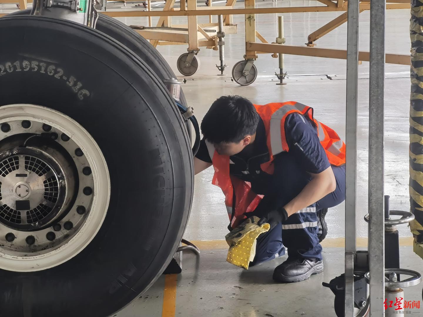 ▲一名飞机维修师正在检修飞机轮胎