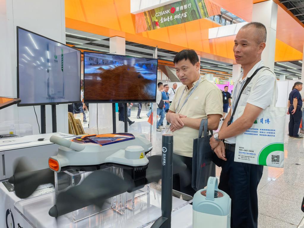 　　展台前的平仓机器人吸引了不少客商驻足。新华社记者武江民 摄