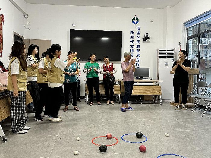 图为艺路生花文化传承实践队队员在龙船塘社区举办“果蔬套圈”活动