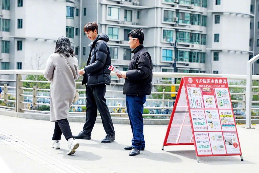 2025年4月，上海一房产中介的工作人员走上街头推销二手房。本文图/视觉中国