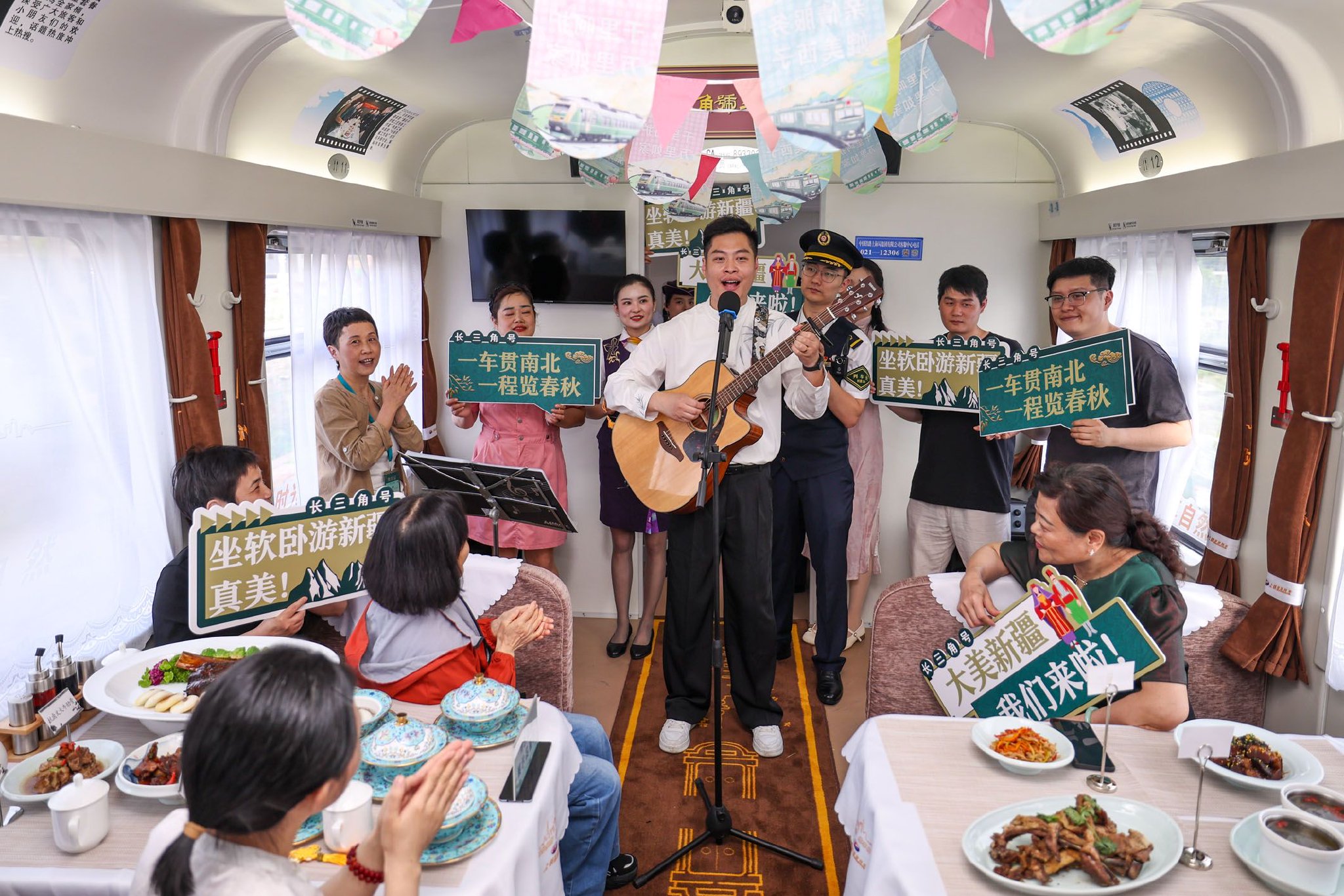 图为杭州客运段列车员在Y476/7次“长三角号”援疆银发旅游专列上为旅客进行文艺表演。新华社记者　江汉　摄