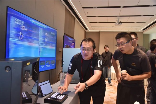 （工作人员为现场嘉宾演示AI超级慢动作系统操作）