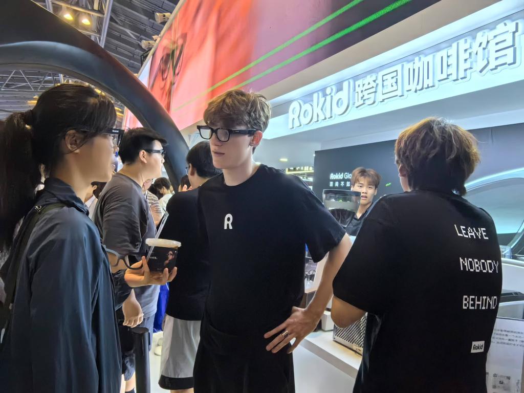 一位观众在智能眼镜展台的“跨国咖啡馆”区域，体验用眼镜与工作人员“交流”，领取咖啡。新华社记者龚雯摄