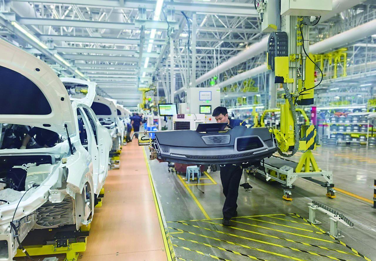 一名工人在长安汽车数智工厂总装车间安装车辆零部件