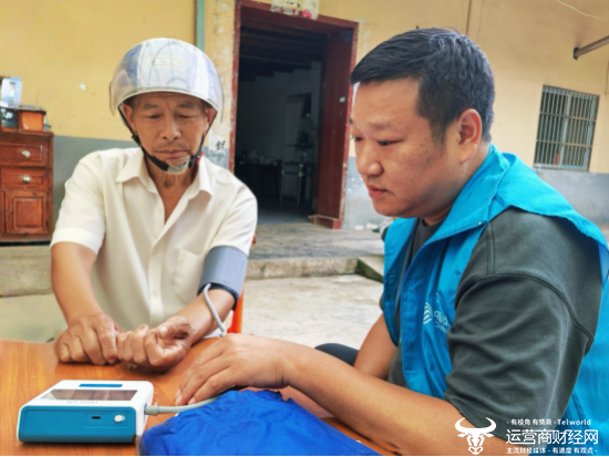 （湖北移动工作人员演示智能血压仪的操作）