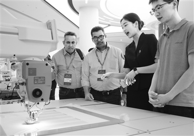 在位于浙江台州的某公司，工作人员在介绍智能缝纫设备。 新华社记者 翁忻旸摄