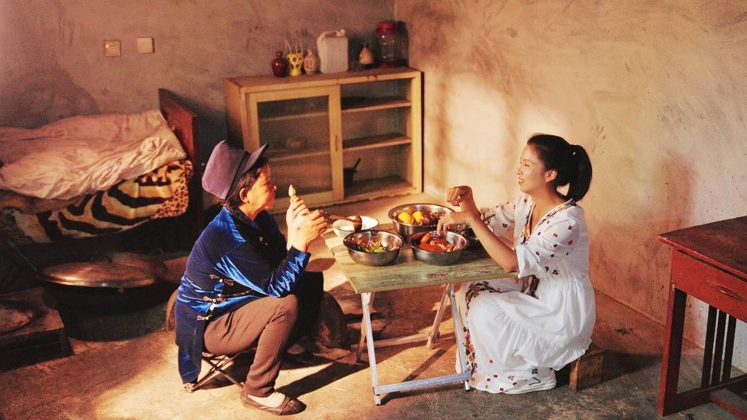 ▲ 阿吉么日歪托人从多多买菜下单了青蟹，与回家过火把节的女儿一起尝鲜。郭元会|摄