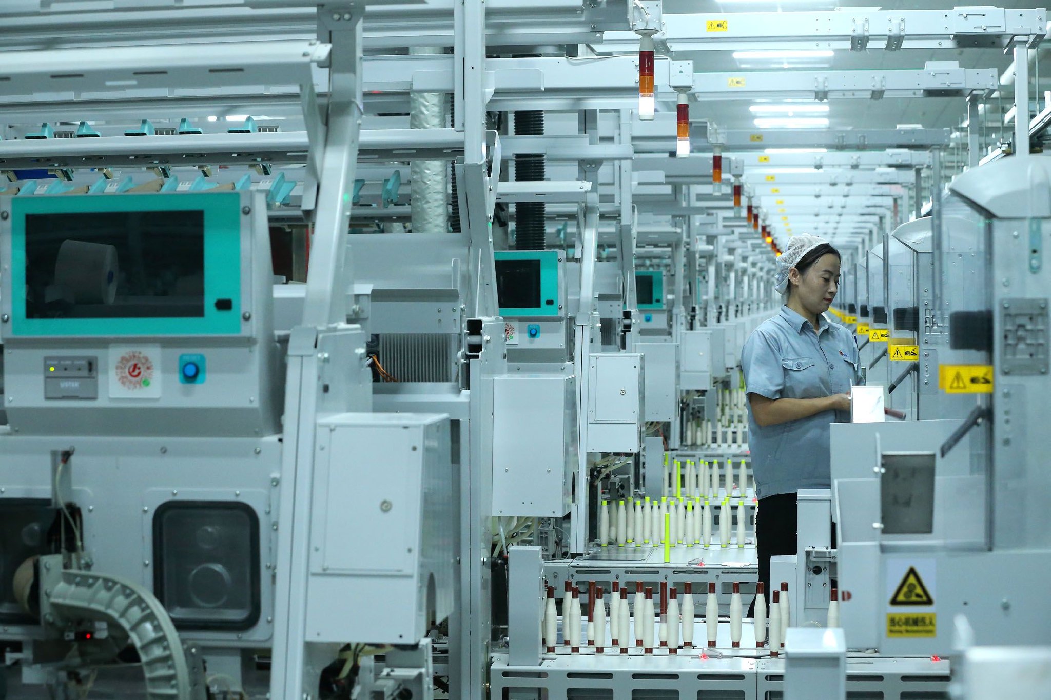 图为青岛市即墨区一家科技纺织企业的工人在智慧纺纱生产线上工作。　新华社发（梁孝鹏　摄）