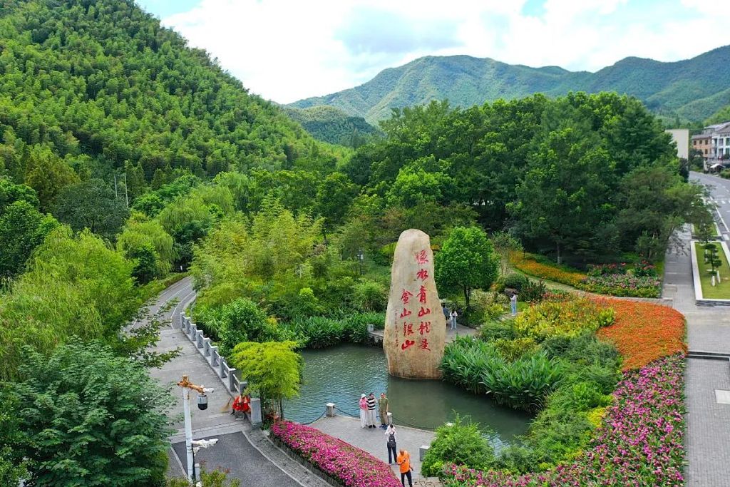 在浙江省湖州市安吉县余村，游客在刻有“绿水青山就是金山银山”的石碑前留影。新华社记者 毛竹 摄