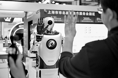 2025世界人工智能大会上，观众在和人形机器人互动。新华社发