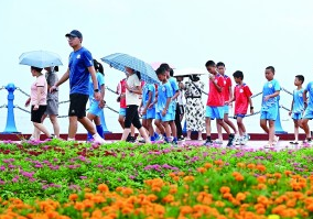 人们在青岛西海岸新区“蓝湾漫道”灵山湾段赏景游玩。新华社发