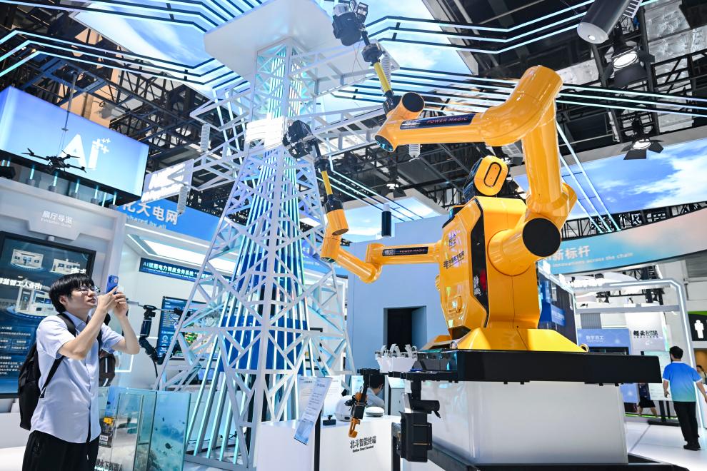7月28日，在2025世界人工智能大会上，参观者在中国南方电网展区拍摄“悟空”带电作业机器人。新华社记者陈浩明摄