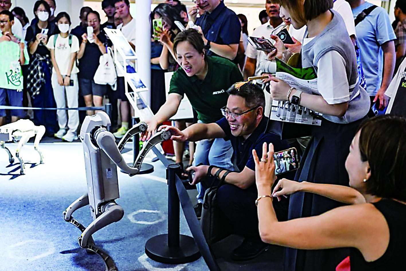 参观者在2025世界人工智能大会展览现场和一款机器狗互动新华社