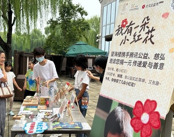 图说：北京慈弘慈善基金会在后海望海楼举办“小红花公益市集”，通过义卖来支持乡村学校图书角建设，受到市民和游客们的欢迎。