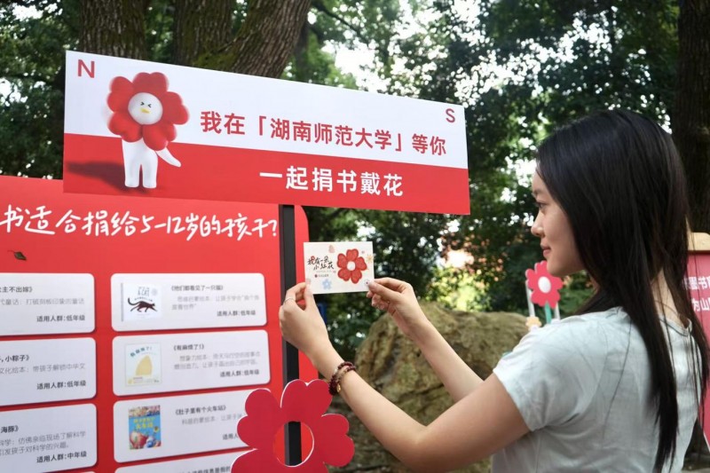 图说：在湖南师范大学，大学生们参与久久公益节，将适合儿童阅读的图书捐赠到乡村学校。