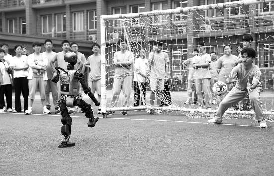 　　日坛中学，人形智能机器人与学生一起踢球。 本报记者 和冠欣 摄