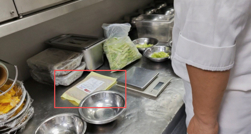 9月12日上午，记者暗访时发现厨师操作台上有“空包装”