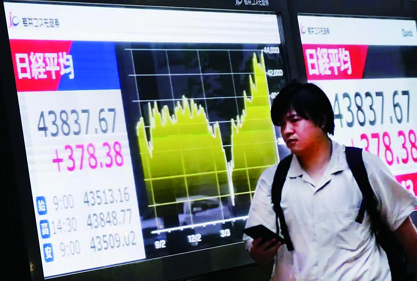 行人经过日本东京一处电子股指显示屏