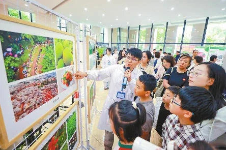 种质库工作人员带领小朋友和家长参观特色种质资源图片展。 本报记者 胡妤雅 摄