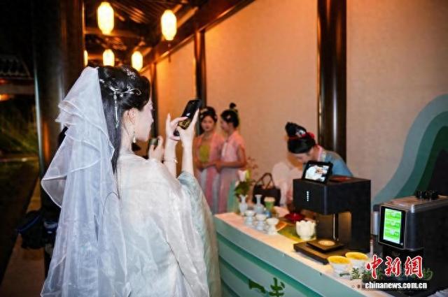 9月21日晚，游客在“径山智能抹茶机”前拍照。(主办方供图)
