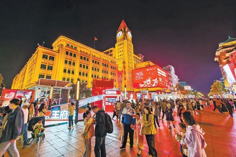 双节假期，京城各大商圈人气高涨，王府井大街上游客络绎不绝，百货大楼前热闹非凡。北京日报记者 邓伟摄