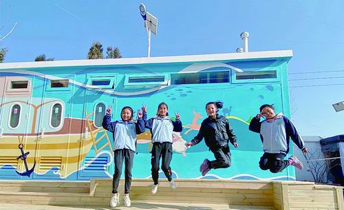 ▲甘肃省东乡族自治县龙泉学校的孩子们在“阳光校厕”前。