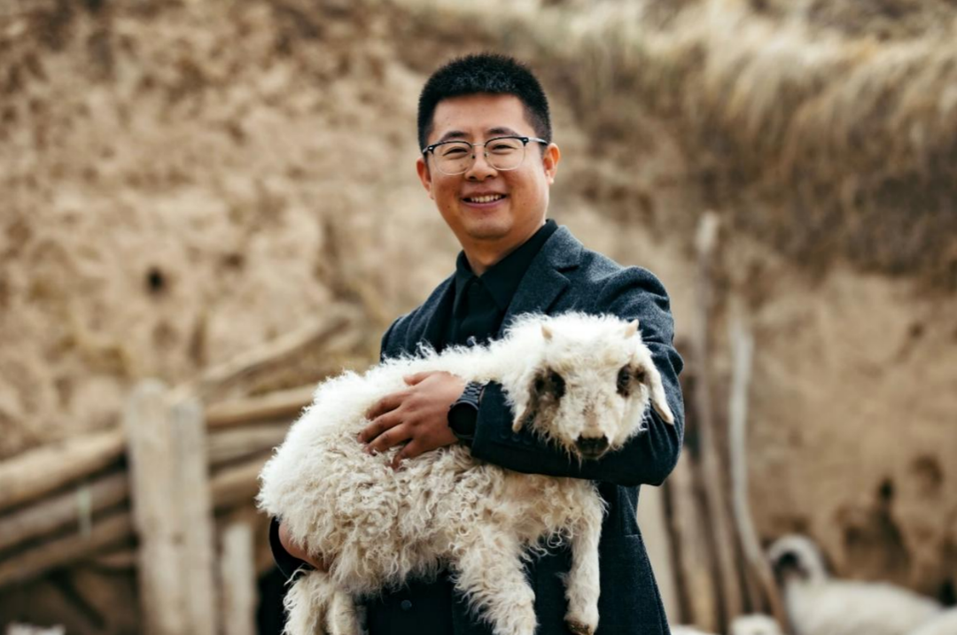 ▲ 在2020年5月18日国新办新闻发布会上，刘国宁通过电商卖羊肉的实践被点名表扬。图为刘国宁与农户养殖的小羊羔。张建  摄