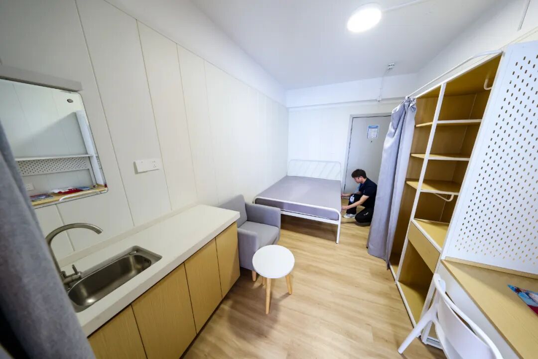 深圳市龙华区白石龙老村44栋，安居乐寓公司的管理员在整理床铺 / 新华社记者 毛思倩 摄