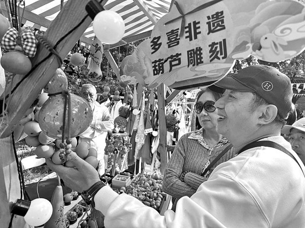 　　北京市月坛公园内，游客在非遗集市选购产品。本报记者 窦新颖摄