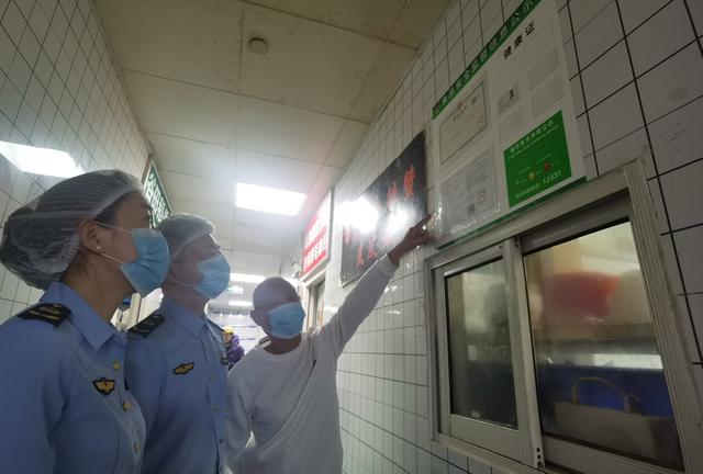 閔行區(qū)市場監(jiān)管局工作人員查驗無堂食餐飲店許可情況，要求“一店一證”。 陳璽撼攝