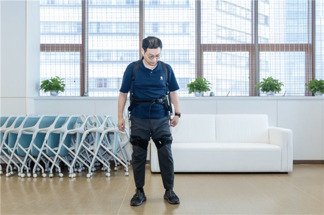 （图注：上海大学机电工程与自动化学院副教授盛博测试穿戴外骨骼进行测试）