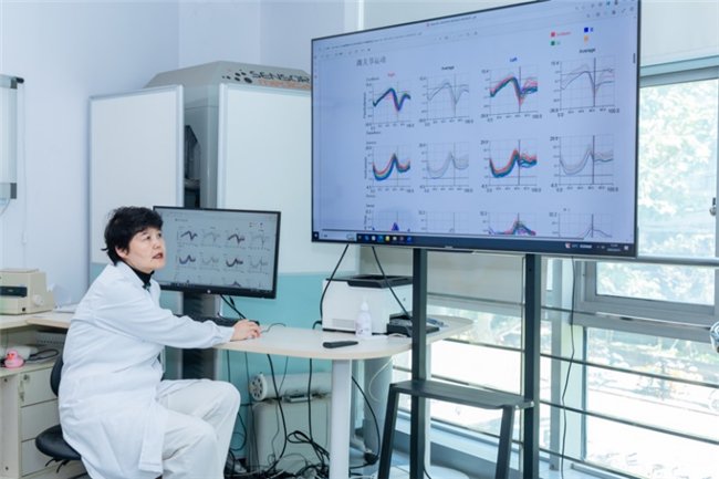 （图注：评审团成员上海中医药大学附属岳阳中西医结合医院主任医师&教授姜淑云比对外骨骼运动数据）