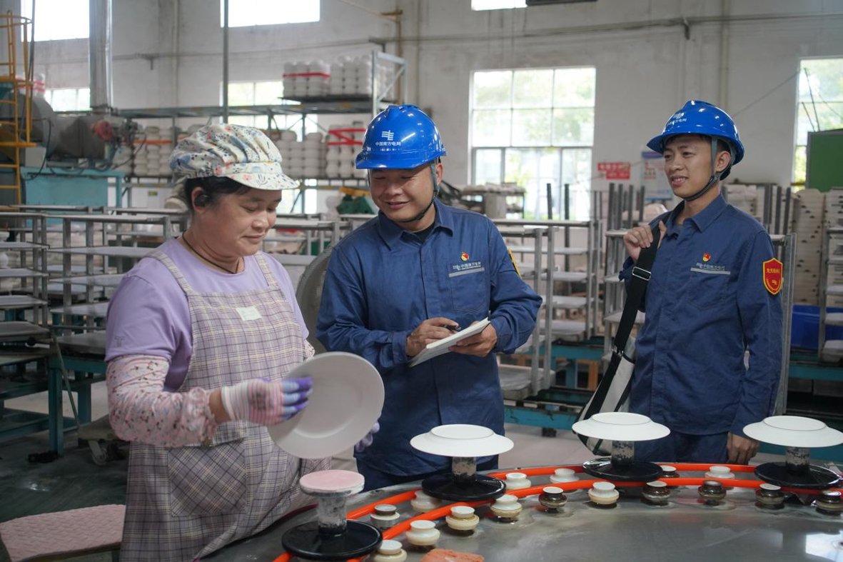南方电网广西玉林北流供电局用电服务人员在淋釉生产线向工人了解电压稳定情况。梁权　摄