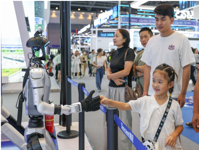 ▲9月8日，在2025世界智能产业博览会现场，一人形机器人与小朋友握手。图/新华社
