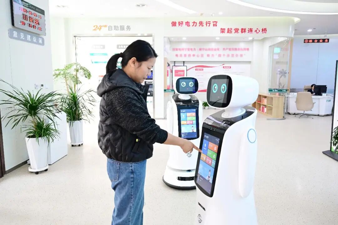 市民在宁夏银川市金凤区智能营业厅利用智能服务机器人办理用电业务。袁弘彦 摄